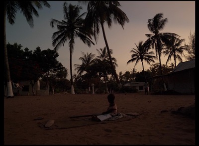 a person sitting on a blanket on a beach