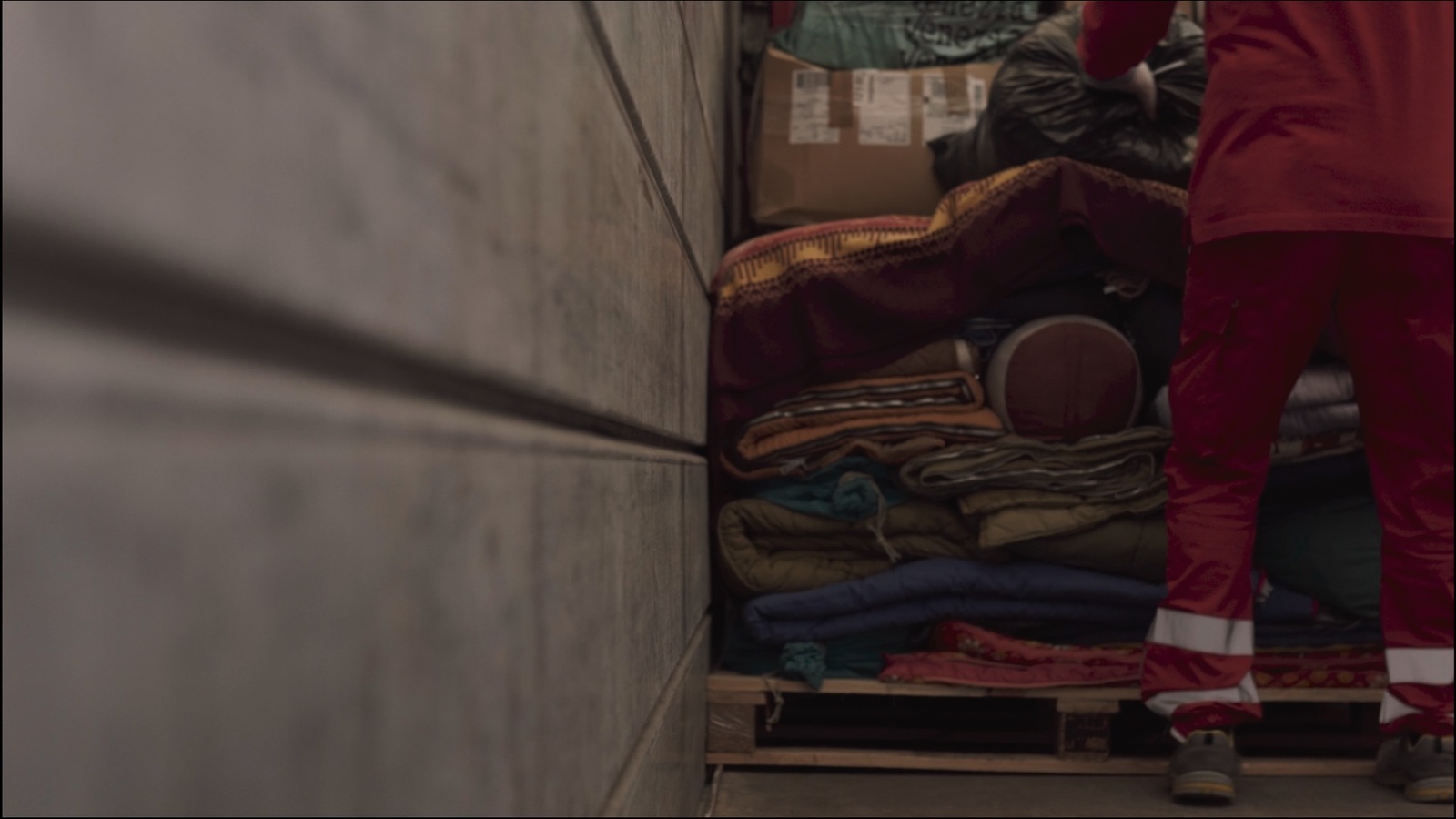 a person standing in a room with a pile of clothes