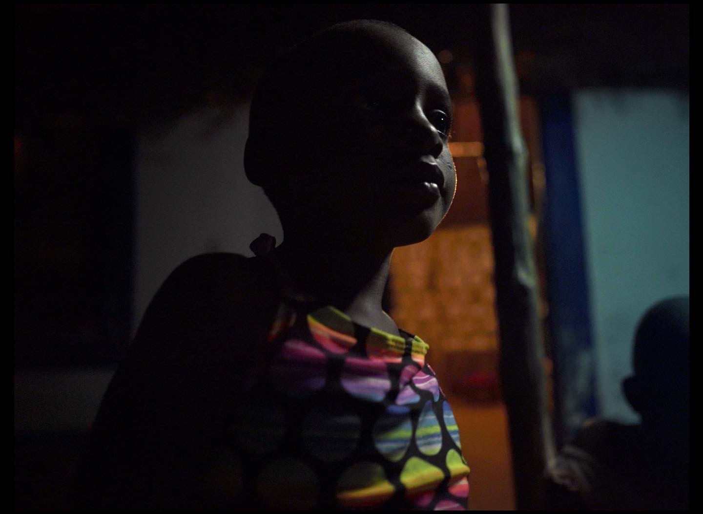 a young child standing in a dark room