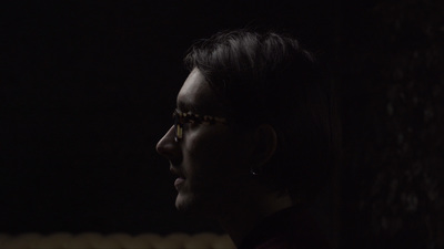 a woman wearing glasses in a dark room