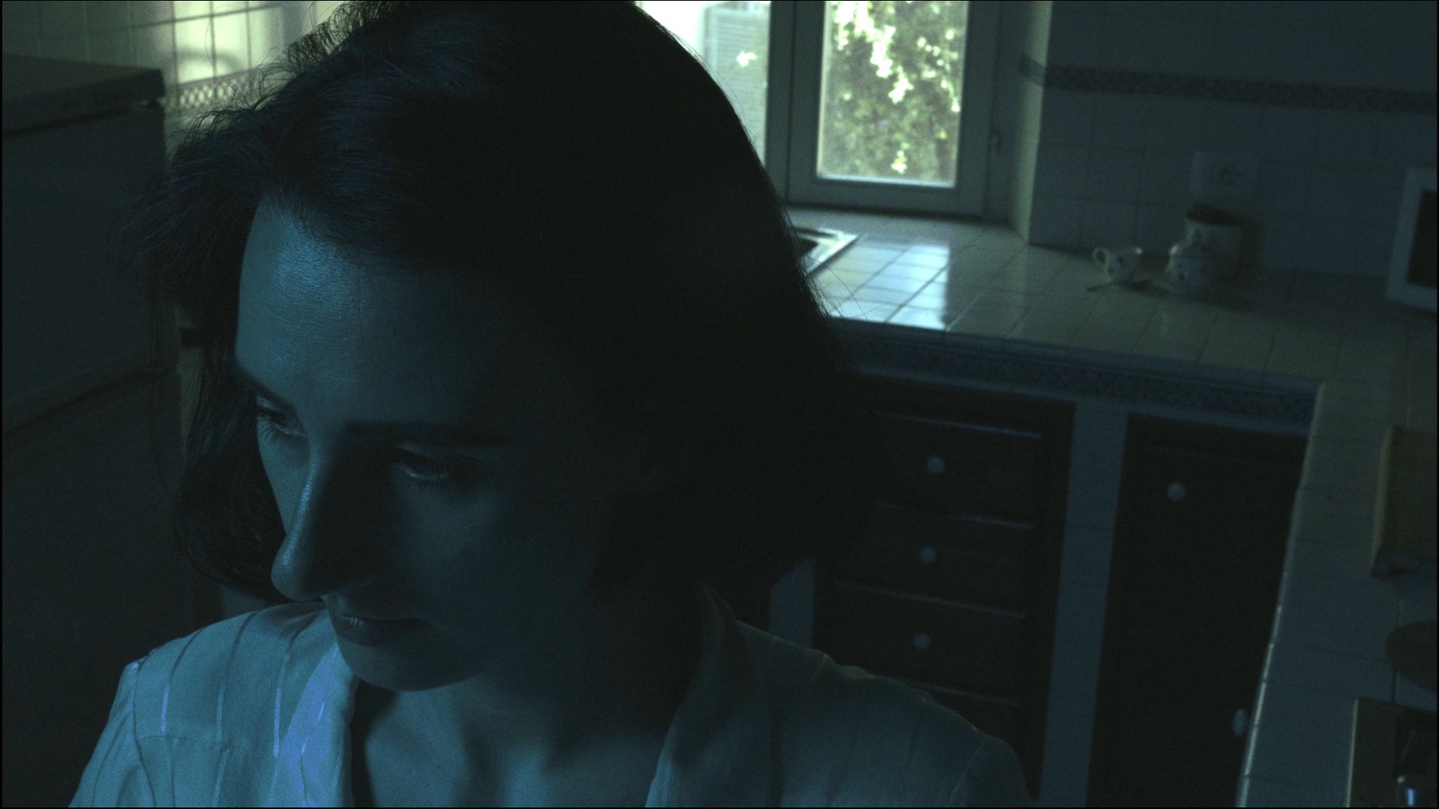 a woman standing in a kitchen at night