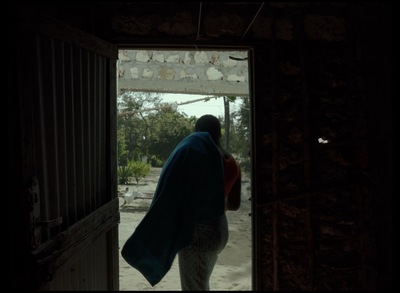 a woman is walking out of a doorway