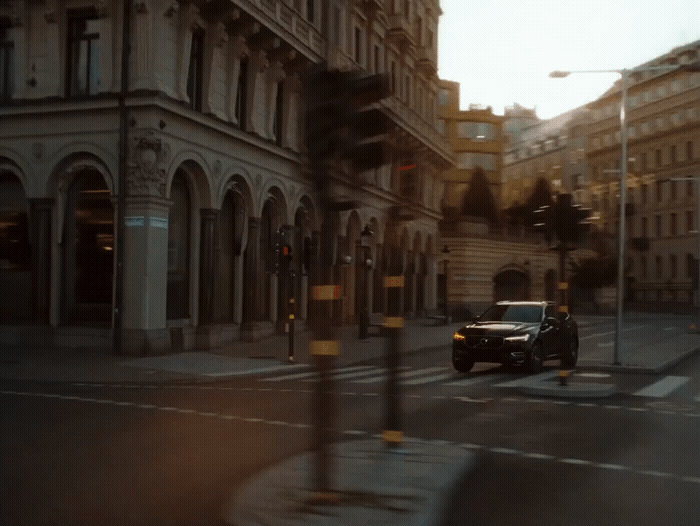 a car driving down a street next to tall buildings