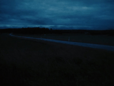 a dark sky with some clouds and some trees