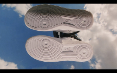 a pair of white and black shoes flying through the air