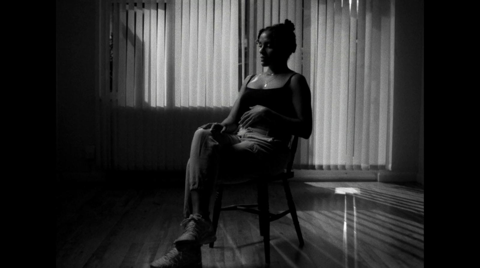 a woman sitting in a chair in front of a window