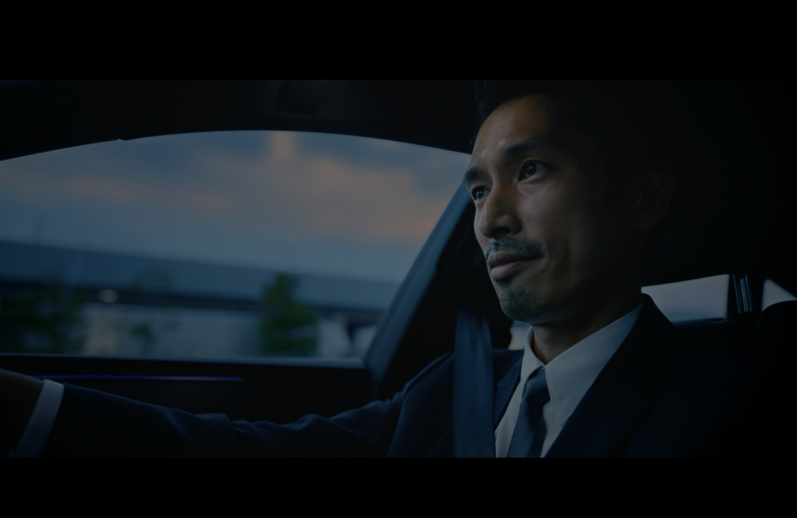 a man in a suit sitting in a car