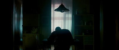 a person sitting at a table in a dark room