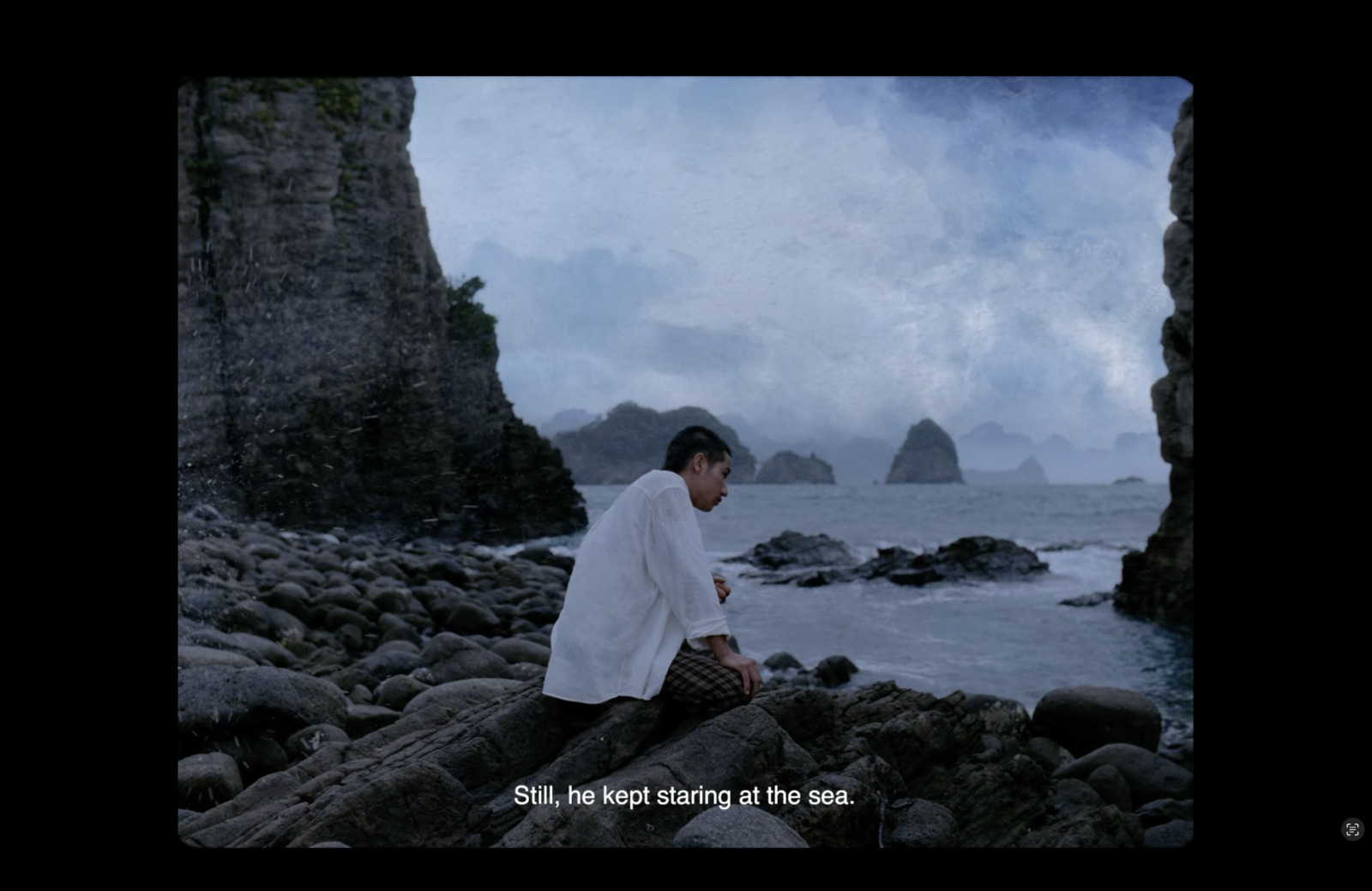 a man sitting on a rock near the ocean