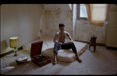 a man sitting on a mattress in a room