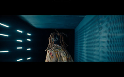 a man with dreadlocks standing in a dark room