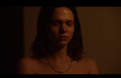 a woman wearing a necklace in a dark room