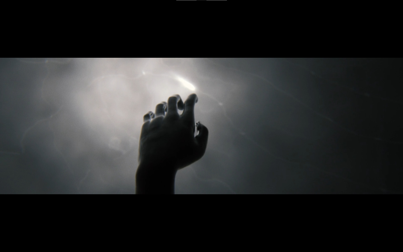 a person's hand reaching up into the sky