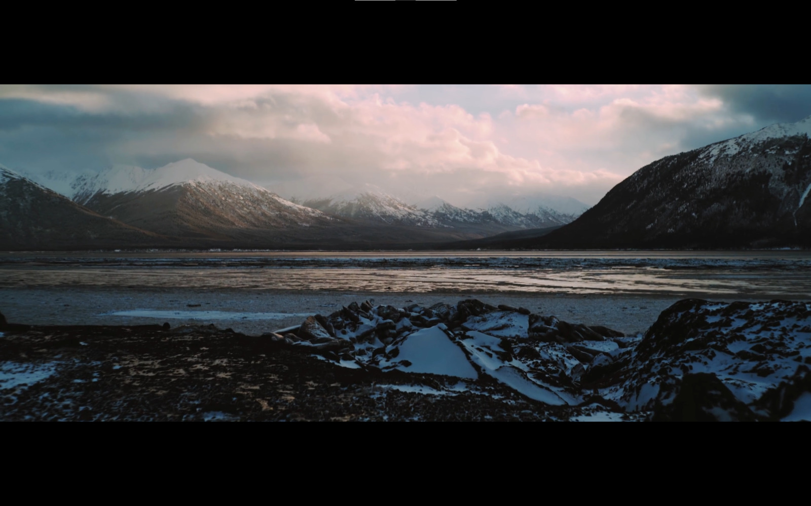 a view of a mountain range with snow on the ground