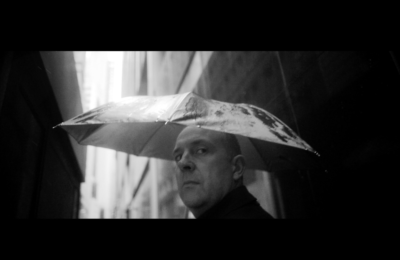 a black and white photo of a man holding an umbrella