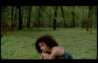 a woman sitting in the middle of a forest