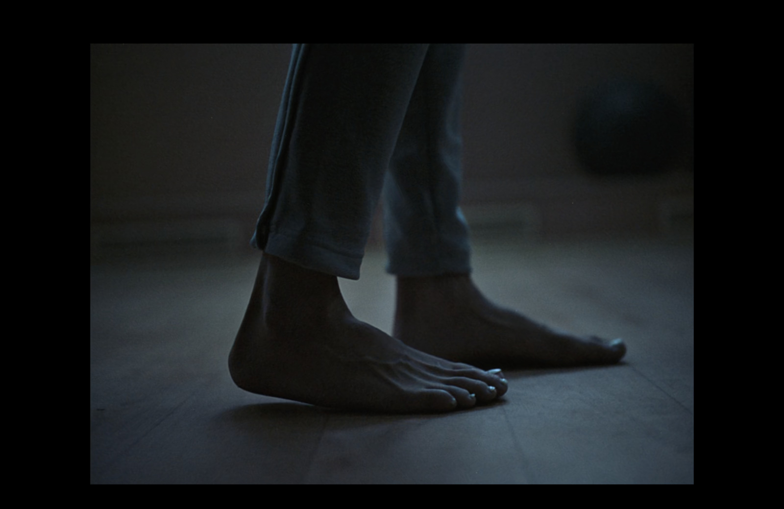 a person standing on a wooden floor with their bare feet