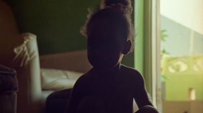 a little girl sitting on a bed in a room