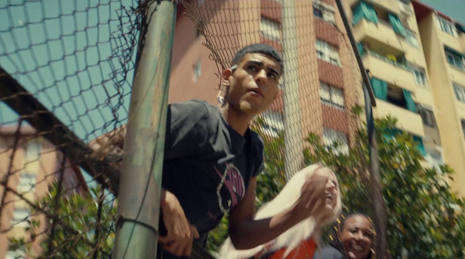 a man holding a frisbee in front of a net