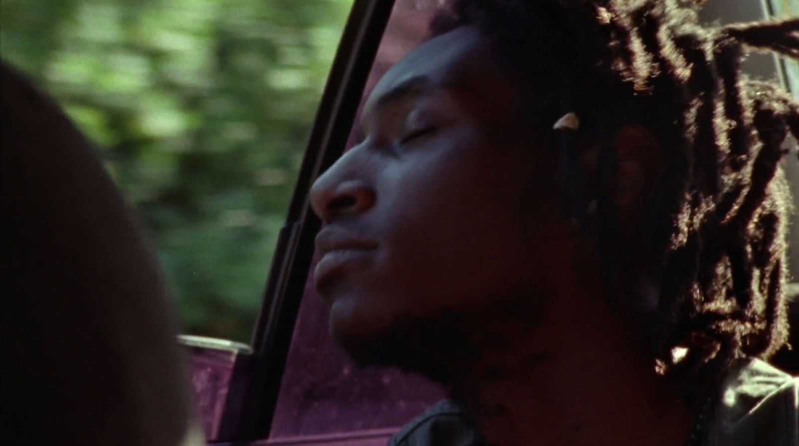 a man with dreadlocks sitting in a car