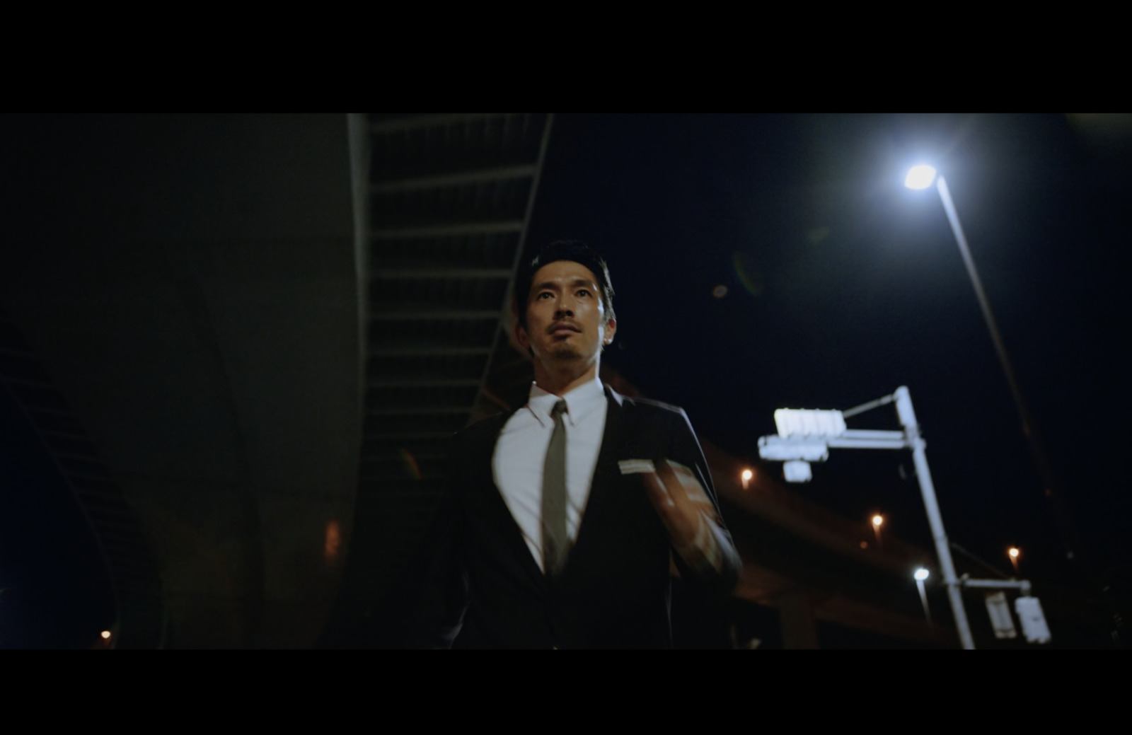 a man in a suit and tie walking down a street