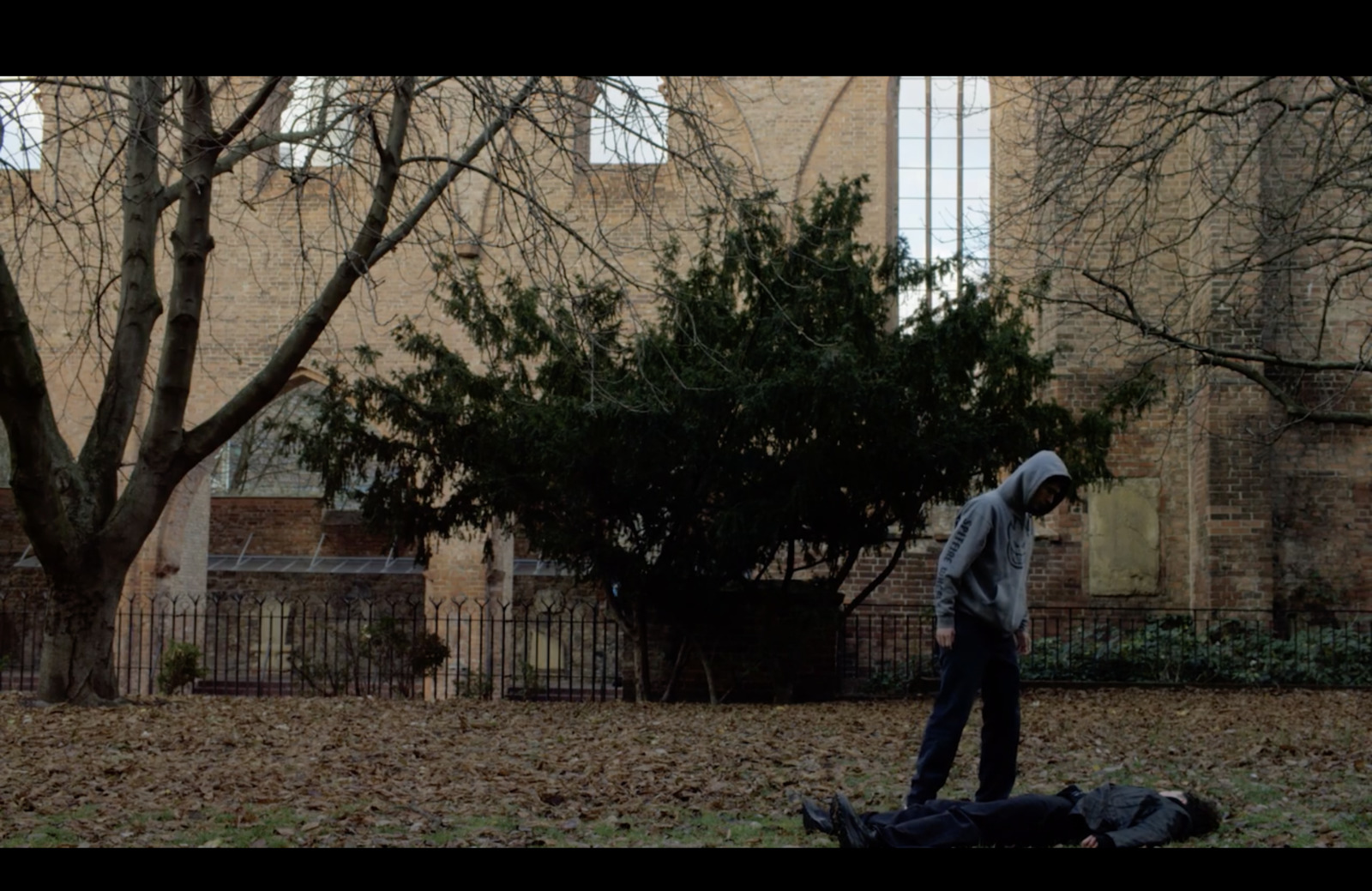 a man is walking in the park with a frisbee