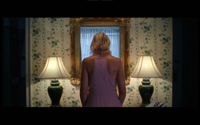 a woman standing in front of a mirror in a room