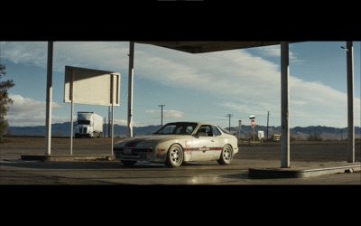 a car parked in a parking lot next to a gas station