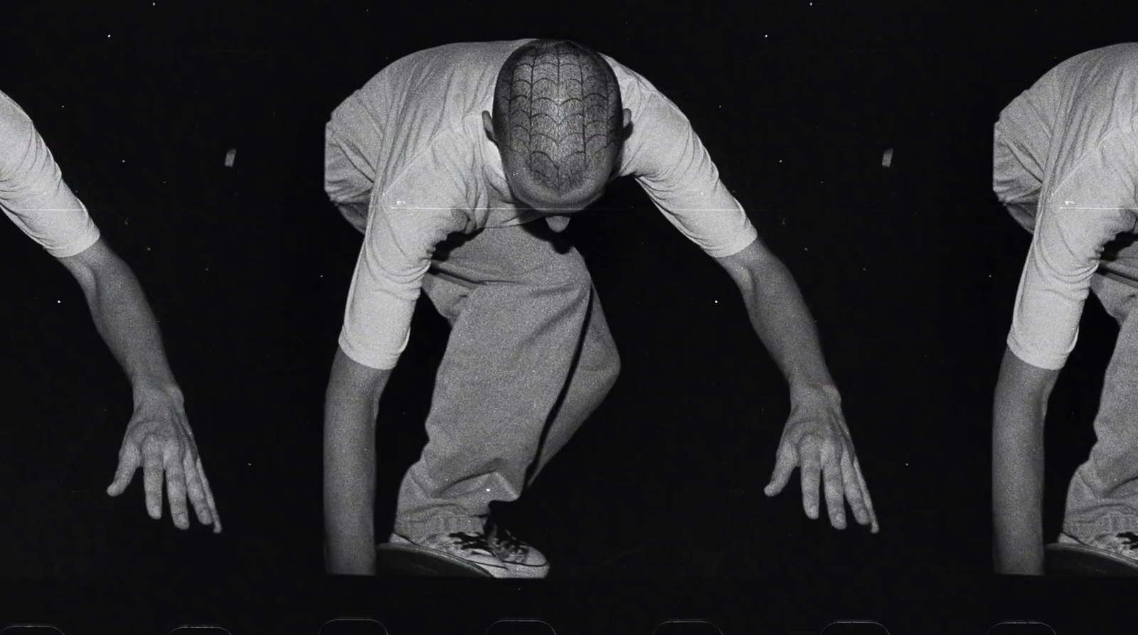 a black and white photo of a man bending over