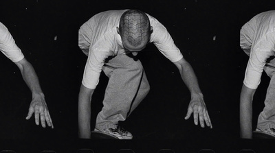 a black and white photo of a man bending over