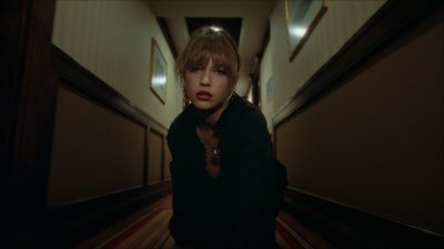 a woman standing in a hallway with her hands on her hips