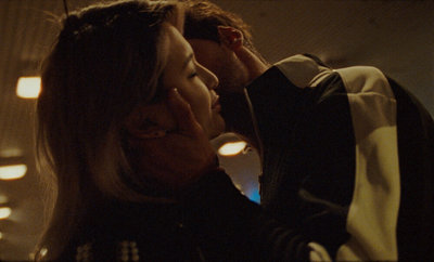 a man and a woman kissing in a dimly lit room