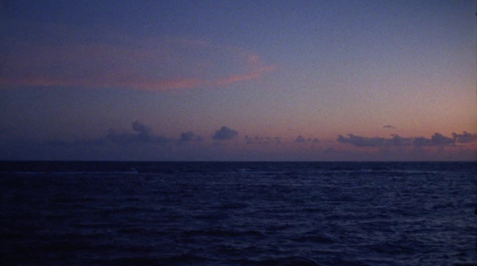 a view of the ocean at dusk from a boat