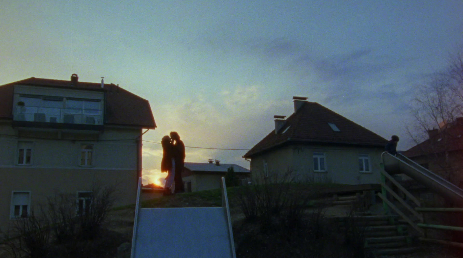 a couple standing on top of a roof next to a building