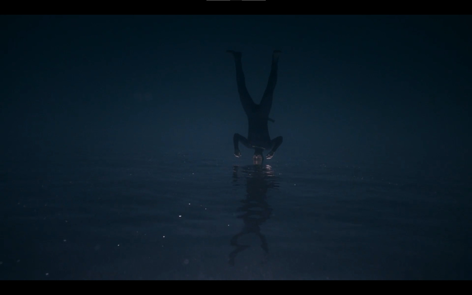 a person standing in the water in the dark