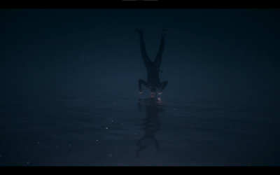 a person standing in the water in the dark