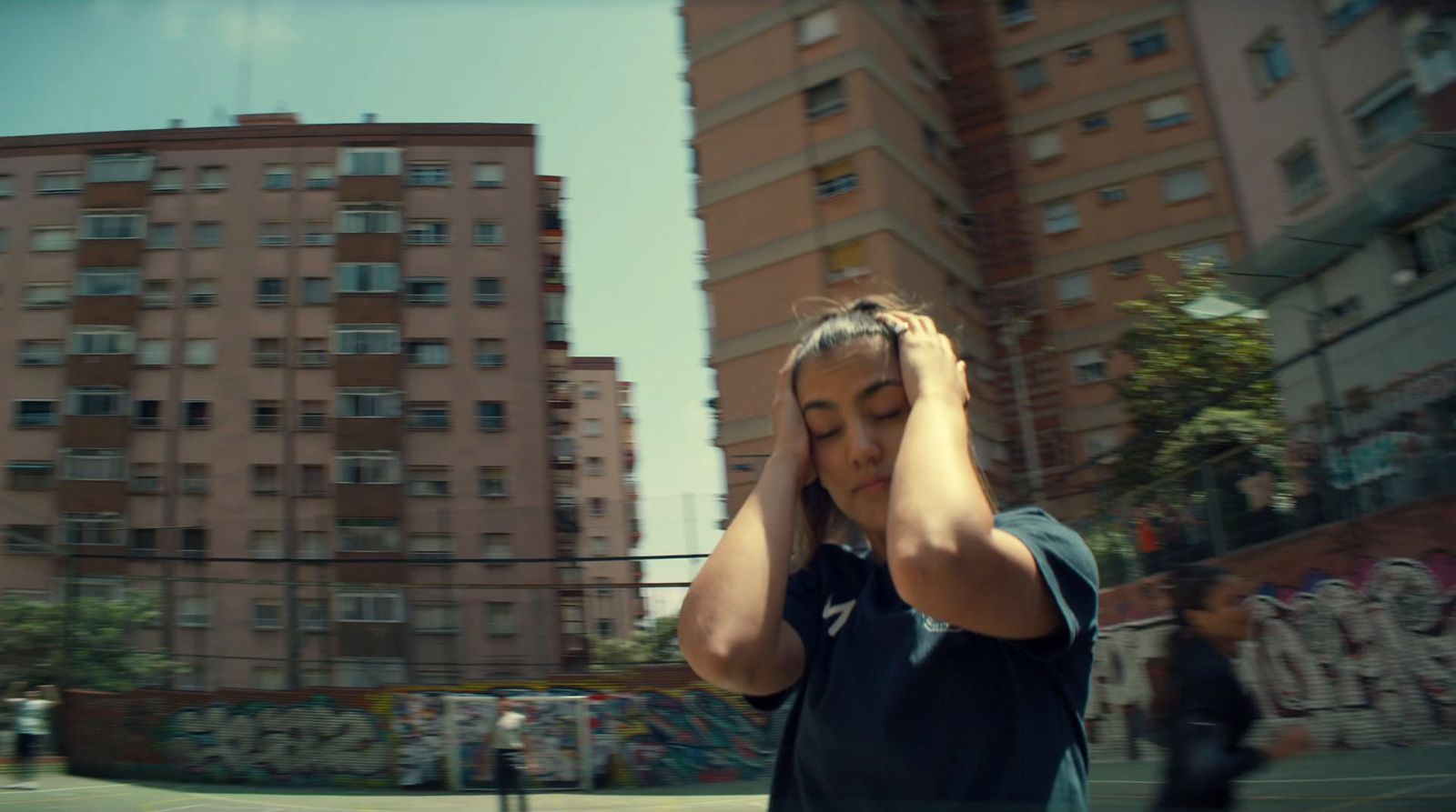 a woman walking down a street while holding her head in her hands