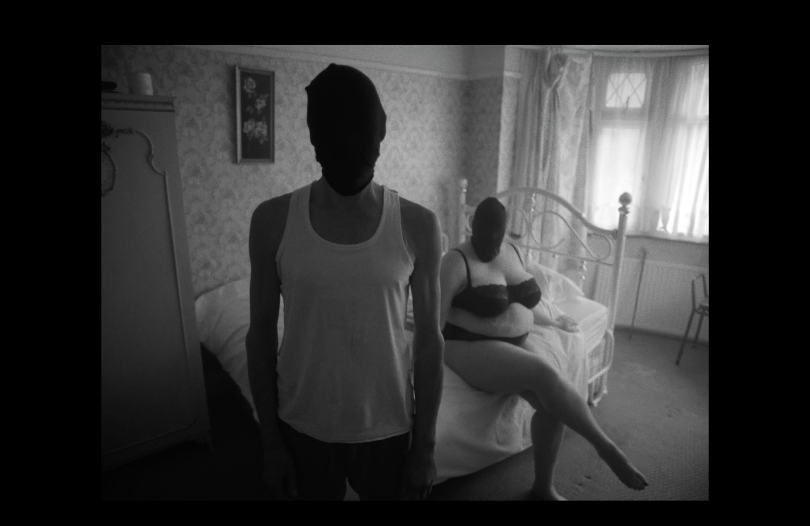 a woman standing next to a man in a bedroom