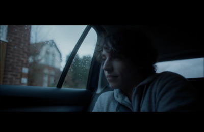 a man sitting in a car looking out the window