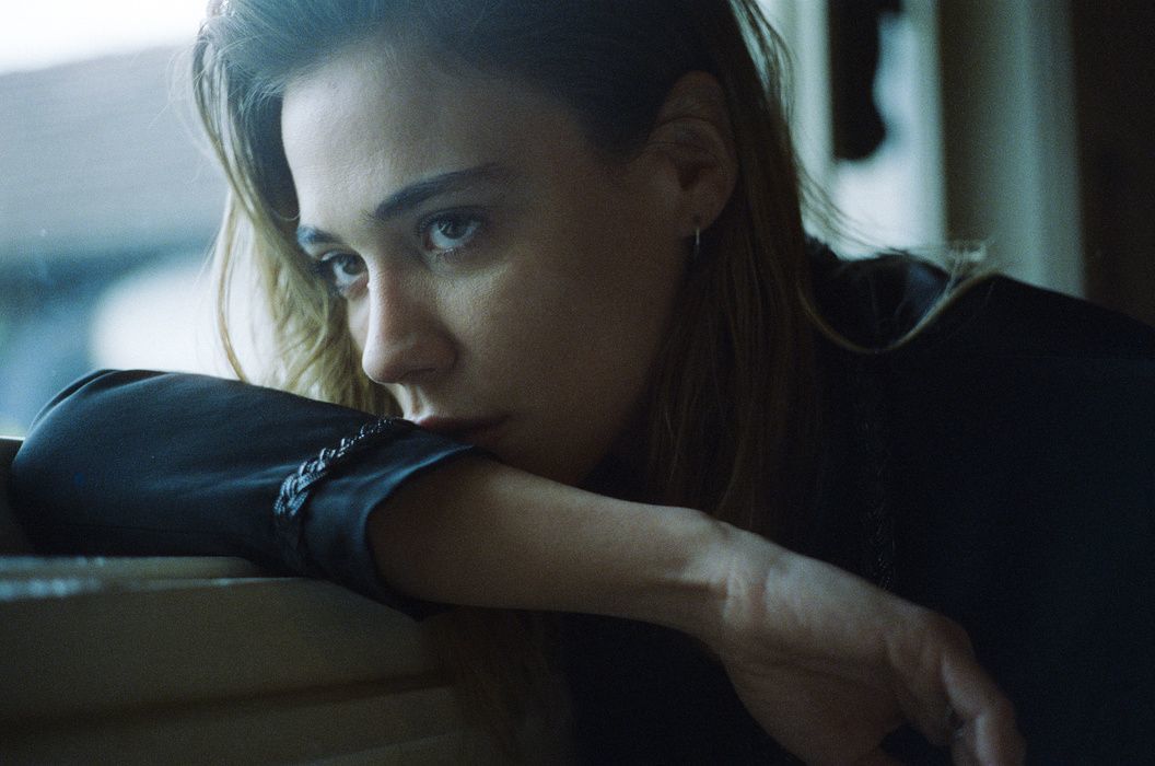 a woman leaning on a window sill with her hand on the window sill