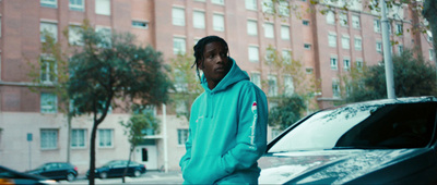 a man standing next to a car in front of a building