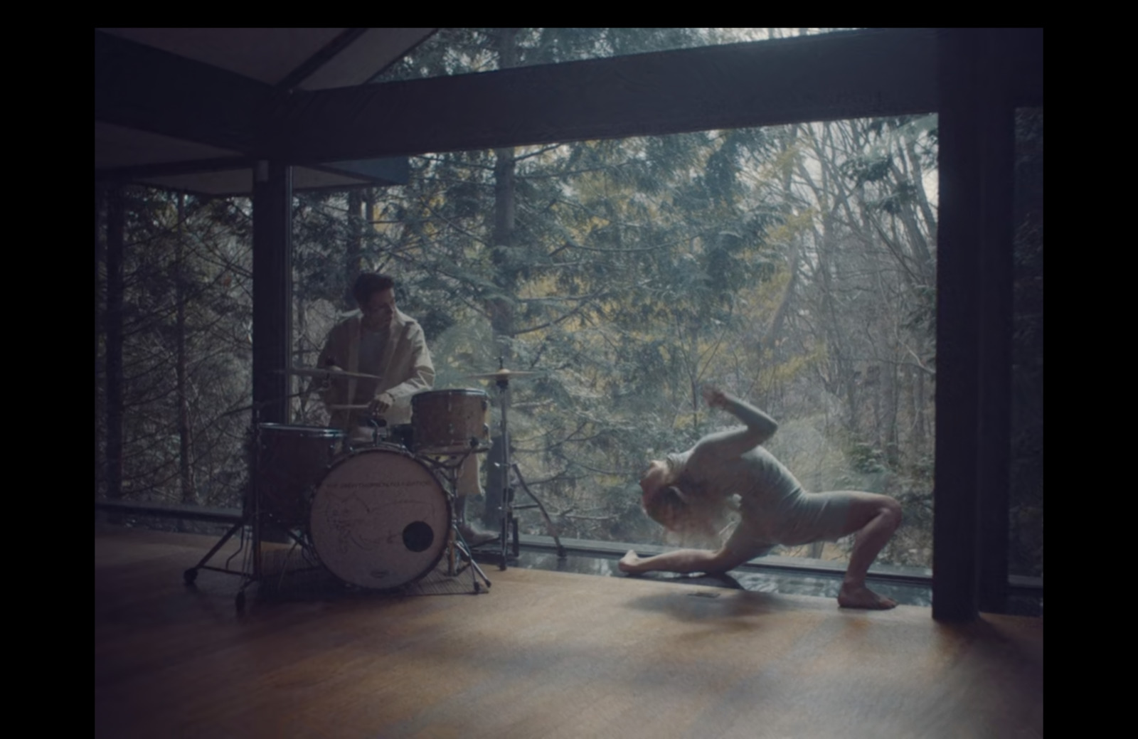 a man is doing a handstand in front of a drum set