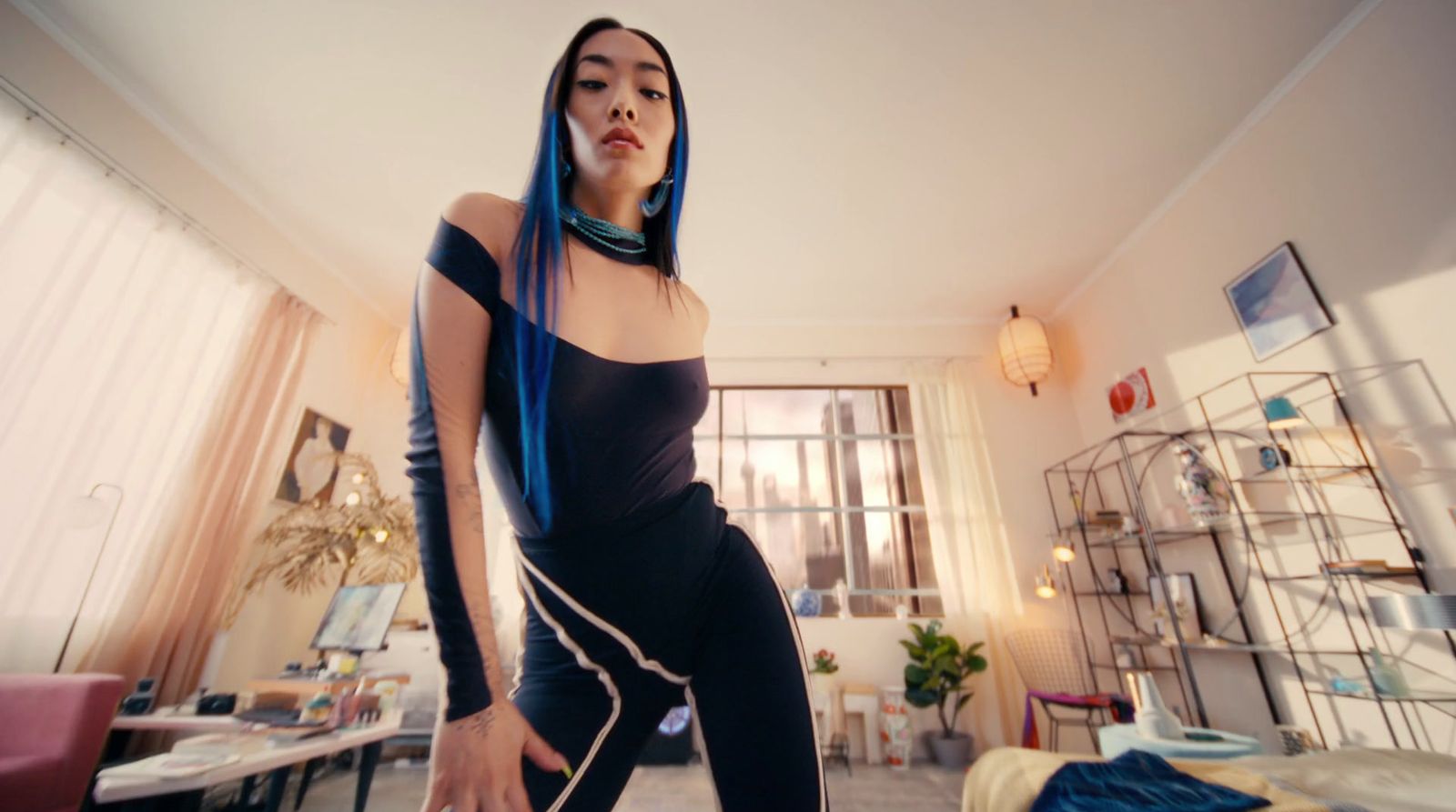 a woman with blue hair standing in a living room