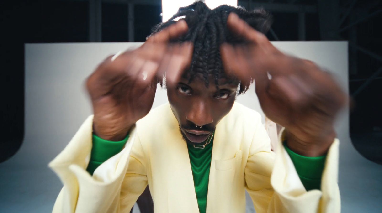 a man with dreadlocks standing in front of a mirror