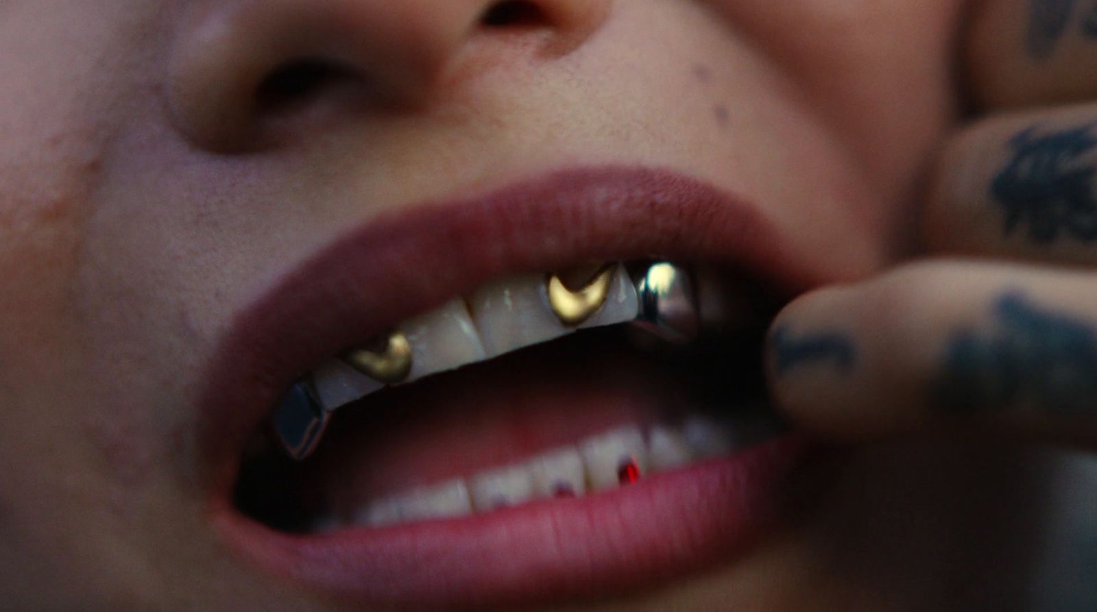 a close up of a person with piercings on their teeth