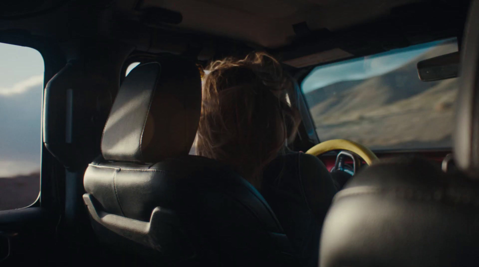 a woman sitting in the passenger seat of a vehicle