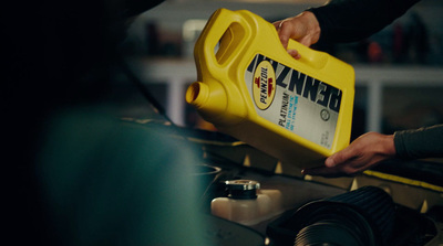 a person is pouring oil onto a car's engine