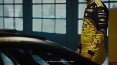 a man standing next to a car in a garage