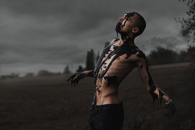 a man standing in a field covered in black and white paint