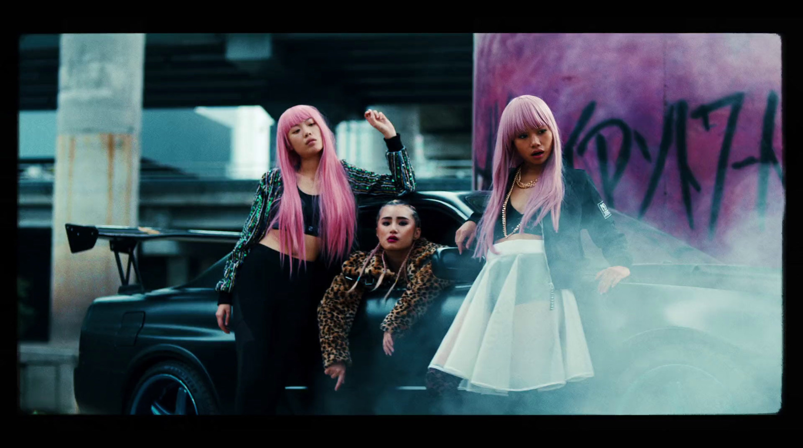 a group of women standing next to each other near a car